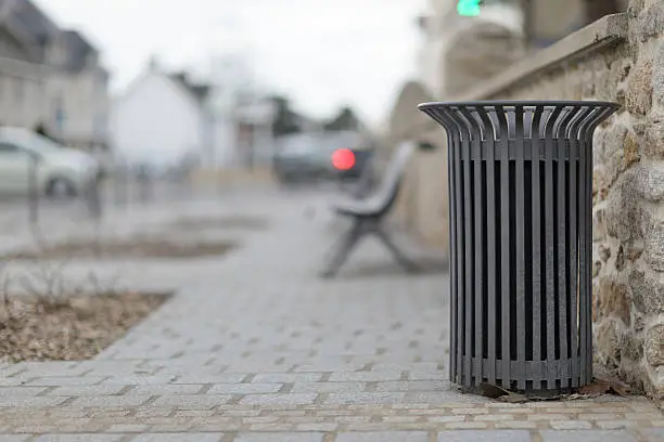 Photo of metallic trash bin in a urban environment