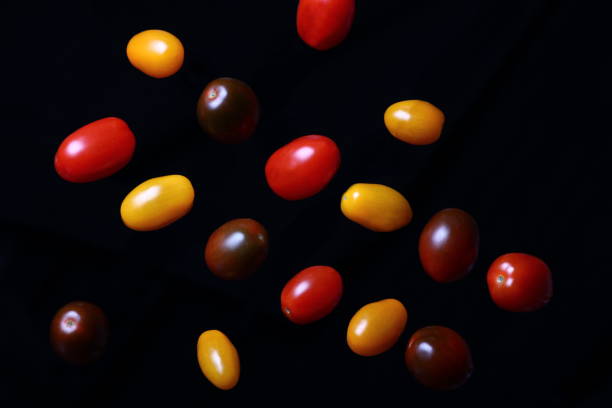 istock multicolored cherry tomatoes with sliced cucumbers in water drops on a dark background 1200670788