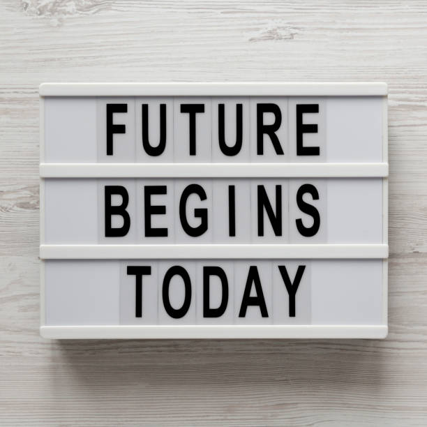 istock 'Future begins today' words on a lightbox on a white wooden background, top view. Overhead, from above, flat lay. Closeup. 1200674655