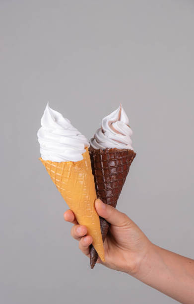 istock hand holding ice cream in waffle cone against color background 1200675187