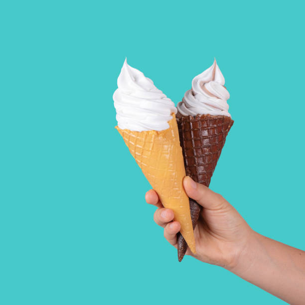 istock hand holding ice cream in waffle cone against color background 1200675192