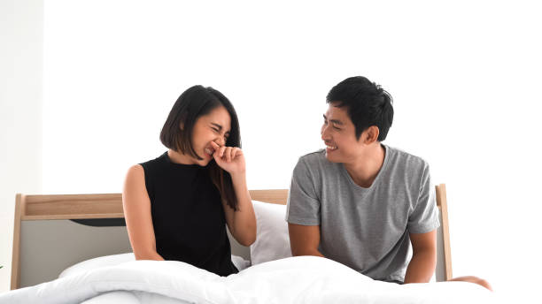 young couple waking up in bed in the morning young couple waking up in bed in the morning bad breath couple stock pictures, royalty-free photos & images