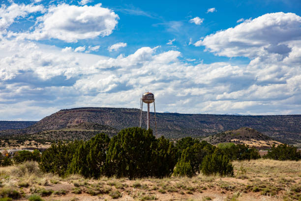 Big, rusty water tank on a tower near the city, reminds us of the old western usa. Chinle, Arizona, US. Chinle, Arizona, USA. May 17, 2019. Big, rusty water tank on a tower near the city, reminds us of the old western usa. Hill and cloudy sky background. chinle arizona stock pictures, royalty-free photos & images