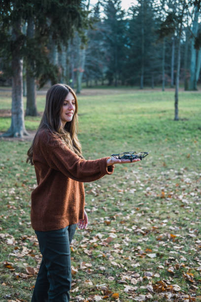 istock Young woman playing with a drone in a park. 1200677410