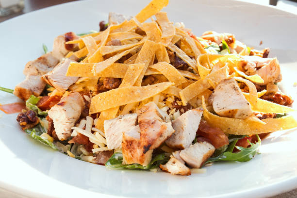 istock Caesar salad with roasted chicken breast, parmesan cheese, lettuce leaf, croutons, cherry tomatoes and cheese sauce 1200678844