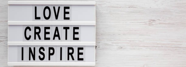istock 'Love create inspire' words on a lightbox on a white wooden background, top view. Overhead, from above, flat lay. Copy space. 1200678926