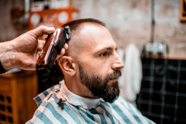 istock Using an electric trimmer to make buzz cut in a barber salon 1200679369