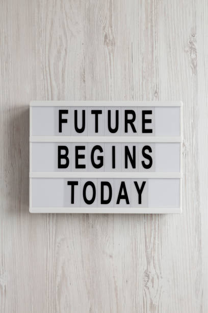 istock 'Future begins today' words on a lightbox on a white wooden background, top view. Overhead, from above, flat lay. 1200679405