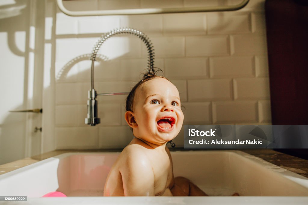 Baby's having a bath Photo of a baby having a bath in a kitchen sink Baby - Human Age Stock Photo