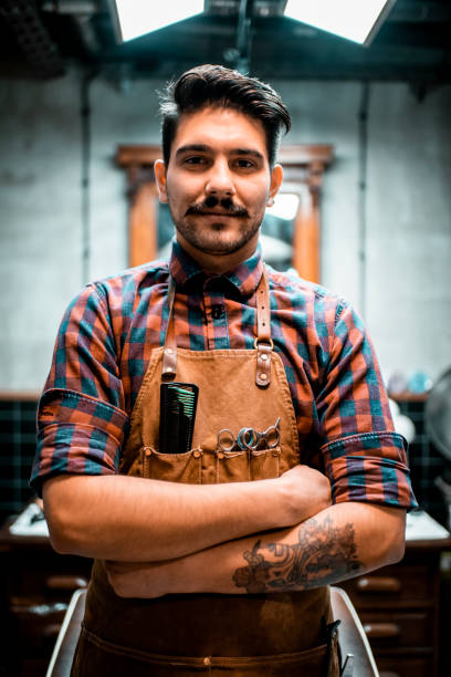 istock A hipster barber in his shop, posing for camera 1200680804