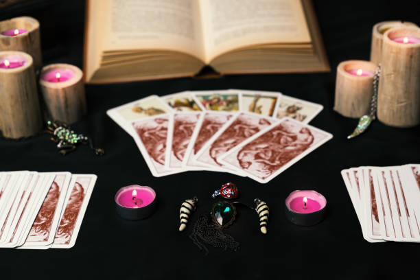 istock Candles and old tarot cards on black silk 1200681103