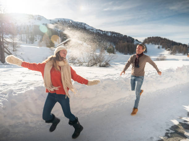 istock Playful couple snowball fighting in winter 1200682262