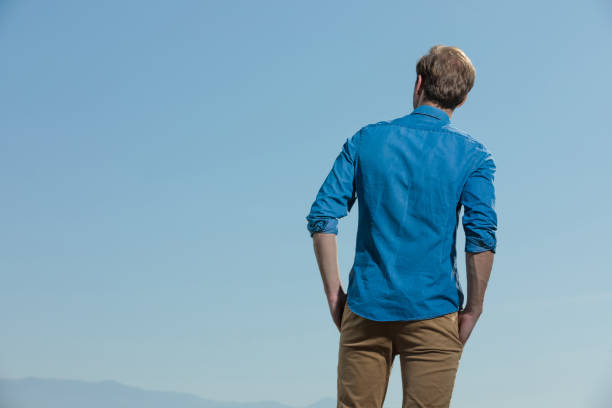 istock casual man standing with hands in pocket looking away 1200682337