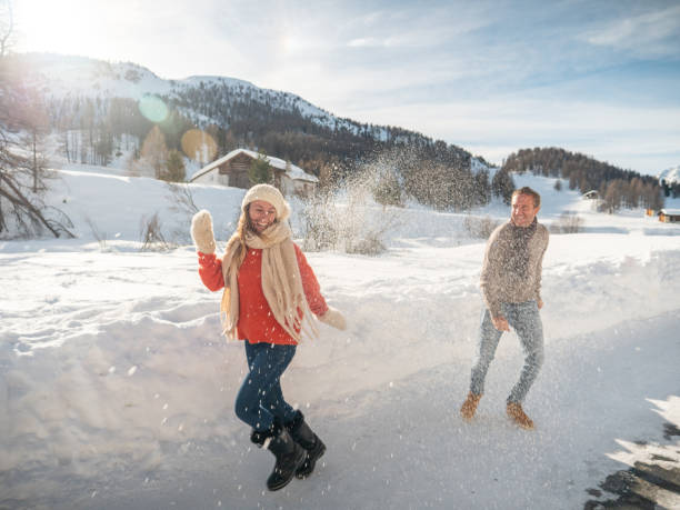 istock Playful couple snowball fighting in winter 1200682368