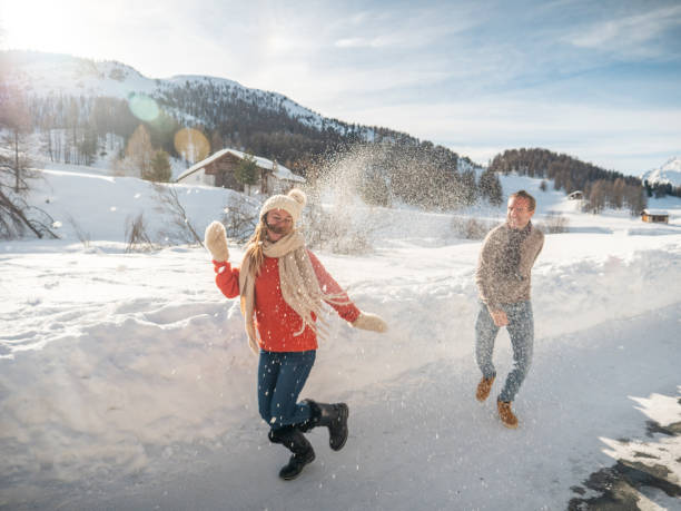 istock Playful couple snowball fighting in winter 1200682422