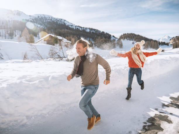 istock Playful couple snowball fighting in winter 1200682493