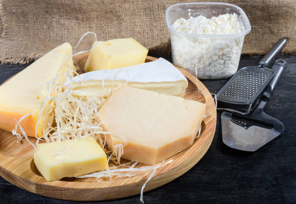 istock Different cheese on wooden dish, cottage cheese, slicer and grater 1200683829