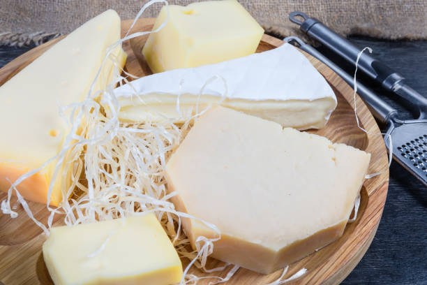 istock Different varieties of cheese on wooden dish in selective focus 1200684362