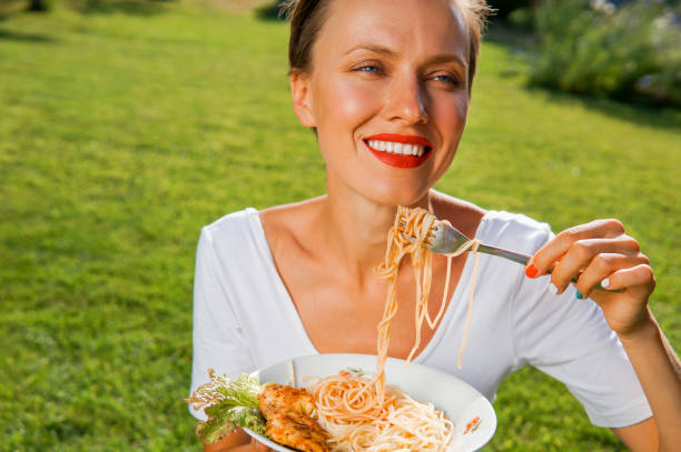 istock Young brunette woman eating spaghetti 1200685080
