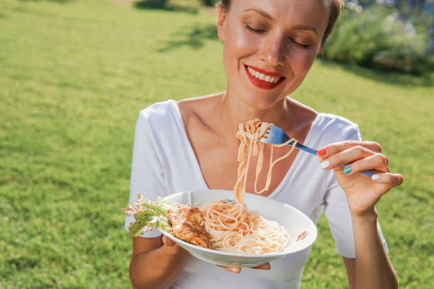 istock Young brunette woman eating spaghetti 1200685660