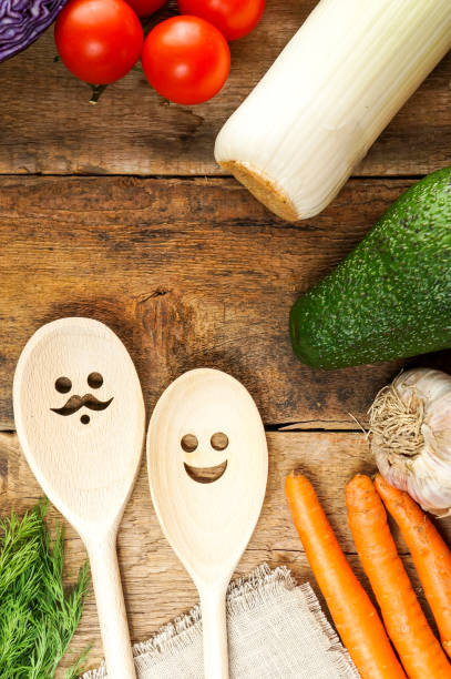 istock Fresh vegetables on wooden table with funny spoons with faces 1200685857