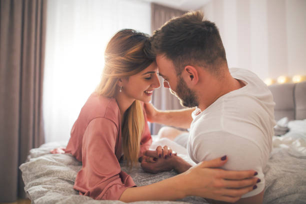 istock Couple in bed holding hands. 1200686225