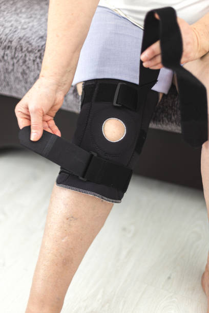 istock Person who puts on protective knee brace, knee support at home 1200688315