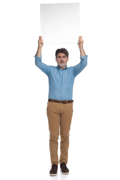 istock Confident casual man holding an empty billboard above his head 1200693045