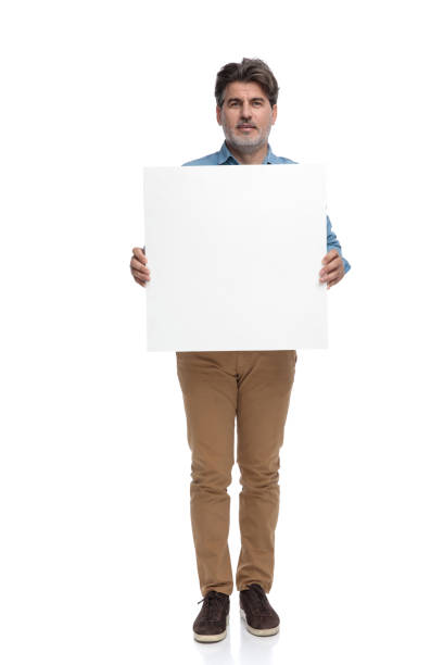 istock Serious casual man holding an empty billboard 1200693077