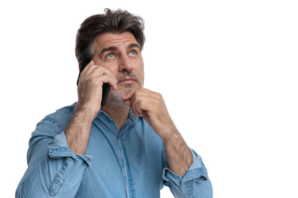 istock Thoughtful casual man talking on his phone, looking up 1200693217