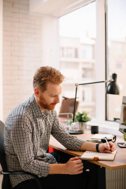 istock Young professional with cell phone in office 1200693374