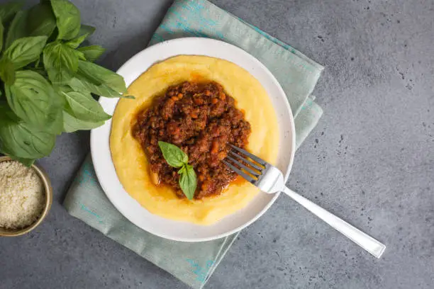 Polenta (boiled cornmeal) with meat-based sauce -  ragù alla bolognese.
