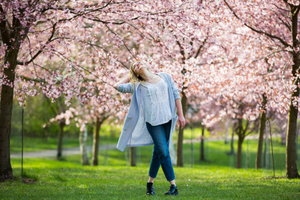 istock Dancing, running and whirling in beautiful park with cherry trees in bloom 1200694775