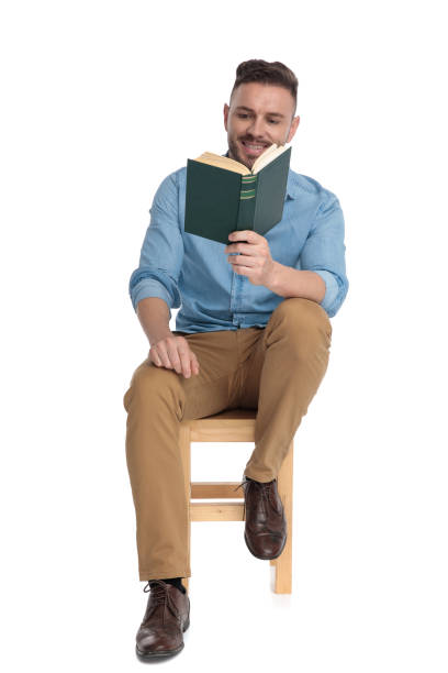 istock happy young man smiling and reading a book 1200696168