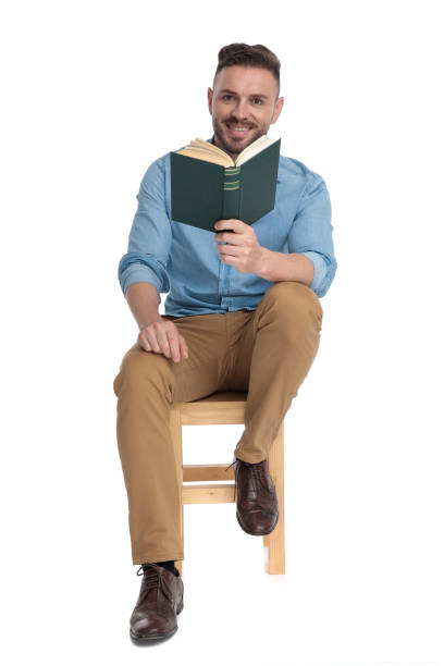 istock happy young man smiling and holding book 1200696682