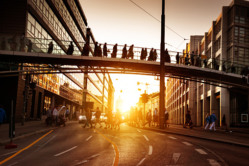 Pedestrians walk across the bridge at sunset in Munich