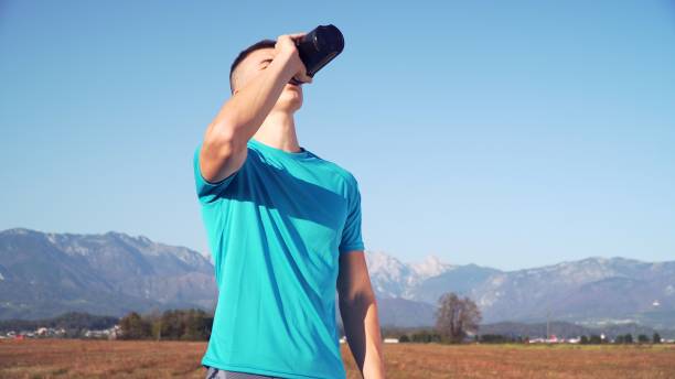 istock fit young man preparing protein shake and drinking it with mountains the back 1200698407