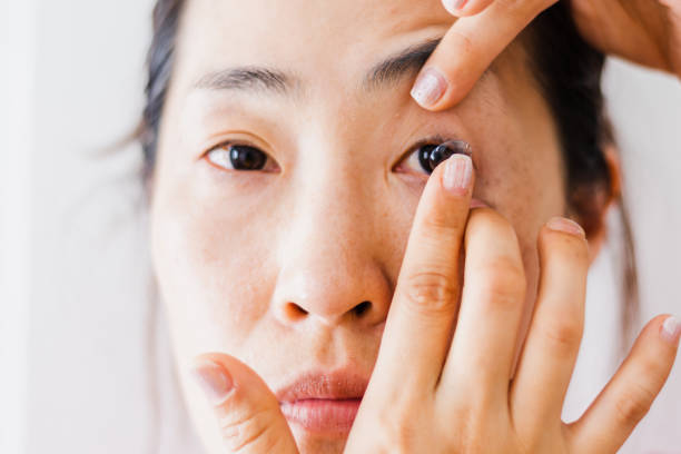 Beautiful Woman Putting Eye Lenses With Hands Contact Lens For Vision. Closeup Of Asian woman With Applying Contact Lens On Her Brown Eyes. Beautiful Woman Putting Eye Lenses With Hands human eye close up eyeball side view stock pictures, royalty-free photos & images