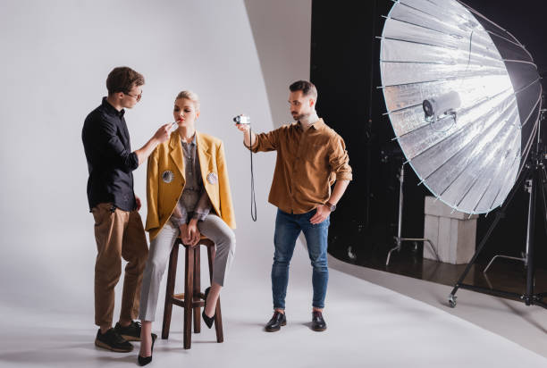 istock photographer shooting how Makeup Artist doing makeup to stylish model 1200700877