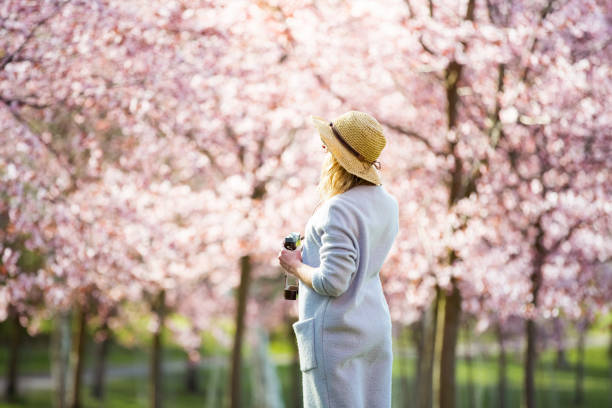 istock Dancing, running and whirling in beautiful park with cherry trees in bloom 1200701304