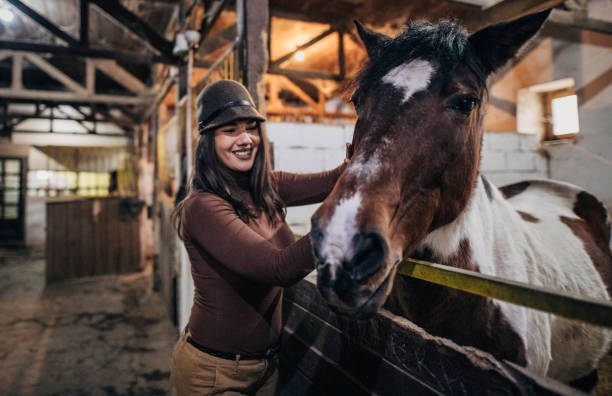 istock Pretty jockey in barn with horse 1200701470