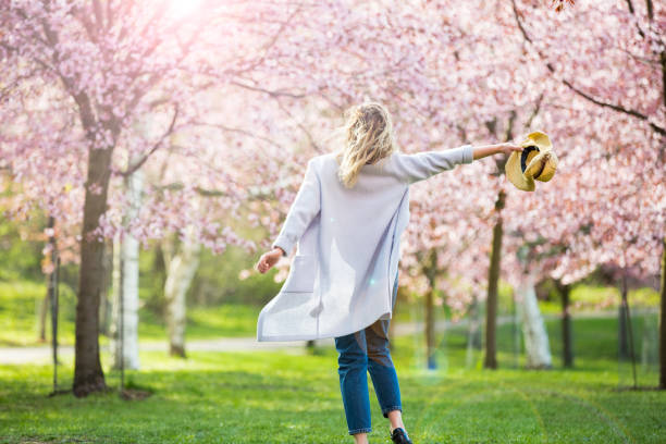 bailando, corriendo y girando en un hermoso parque con cerezos en flor - primavera estación fotografías e imágenes de stock