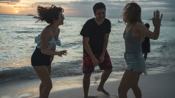 istock three friends having fun at the beach sunset 1200702242