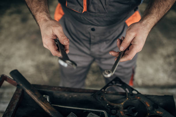 istock Auto mechanic repairing car at service, takes tool 1200702334