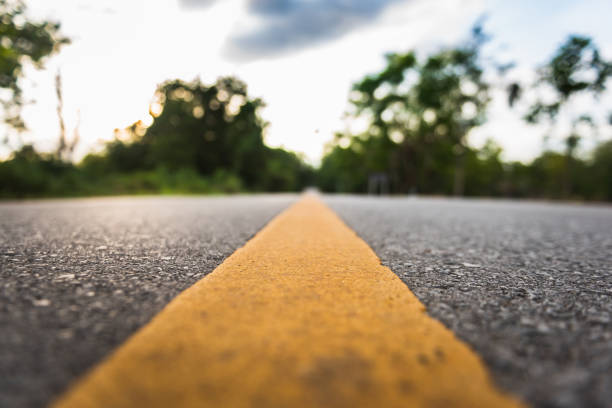 istock asphalt road with yellow diving line and forest background 1200703081