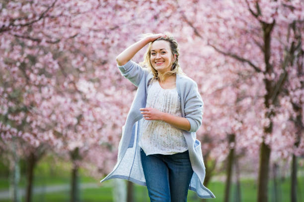 istock Dancing, running and whirling in beautiful park with cherry trees in bloom 1200703834