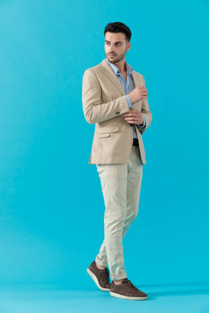 istock cool fashion guy adjusting coat and looking to side 1200703996