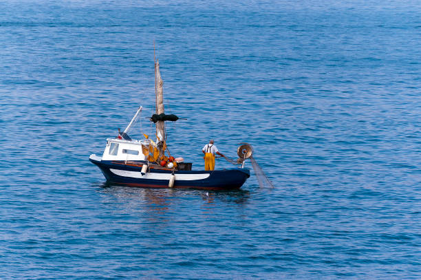 senior fisherman on a small fishing boat - liguria italy - fishing nautical vessel small men imagens e fotografias de stock