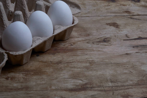 istock Eggs in the container at weathered wooden background copy space 1200705851