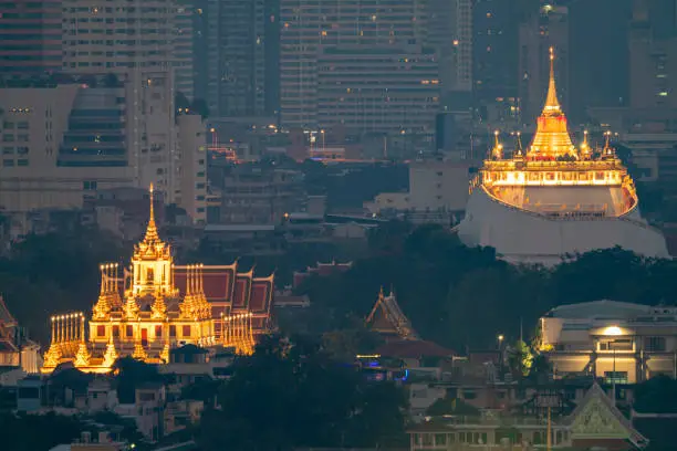 Photo of Golden mountain in Wat Saket Ratcha Wora Maha Wihan and Lohaprasat in Wat Ratchanatdaram Worawihan which is landmark in Bangkok, Thailand with bangkok cityscape background.